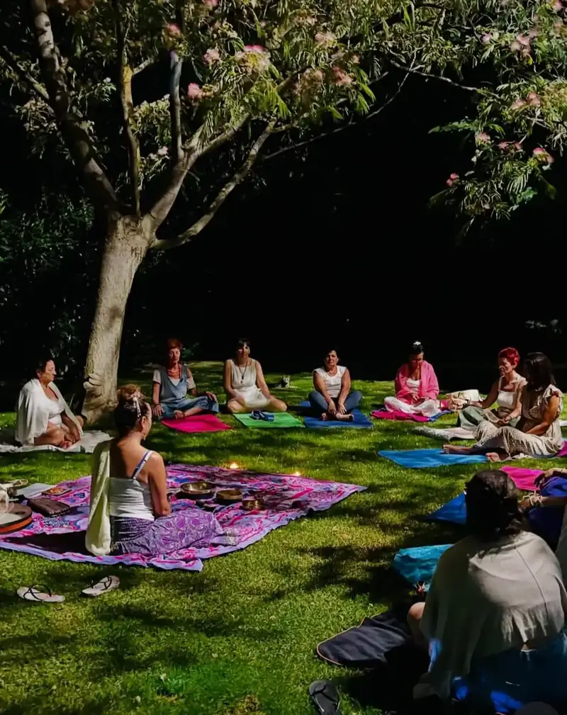 Sessione collettiva di yoga all'aperto nei prati della tenuta